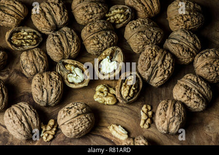 Whole and halves big walnuts lie on a wooden table.  Vegetarian food. Stock Photo