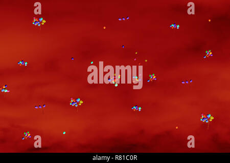 Bright colorful glowing balloons against the background of blood red skies Stock Photo