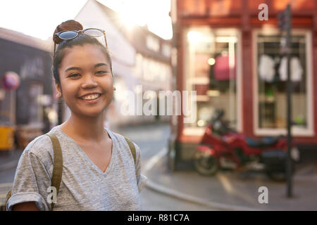 Smiling young Asian woman enjoying an afternoon in the city Stock Photo