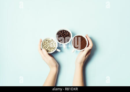 Different types of coffee - ground, grain and unroasted on blue pastel background Stock Photo