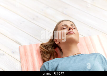 woman doing yoga corpse pose at studio Stock Photo