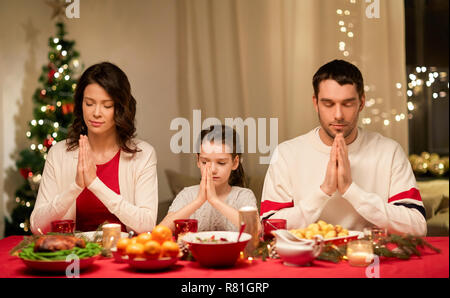 family praying before meal at christmas dinner Stock Photo