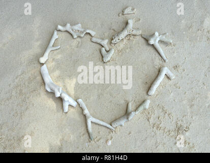 White broken dead coral in heart shape on the beach. Stock Photo