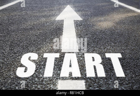 close up of arrow and word start on asphalt road Stock Photo