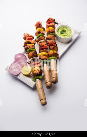 Chicken tikka /skew Kebab. Traditional Indian dish cooked on charcoal and flame, seasoned & colourfully garnished. served with green chutney and salad Stock Photo