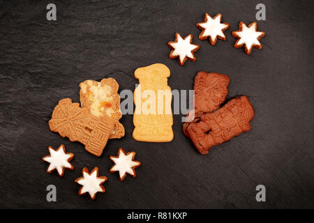 Overhead photo of assortment of traditional Christmas Spekulatius and Zimtsterne cookes, shot from the top on a black background with a place for text Stock Photo