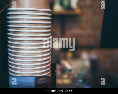 Stack of small brown paper cups made of craft paper prepared for coffee, tea or water in loft style  cafe background with copy space. Stock Photo