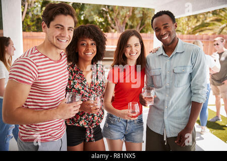Young adult friends at a backyard party, looking to camera Stock Photo