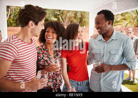 Young adult friends talking at a backyard party Stock Photo