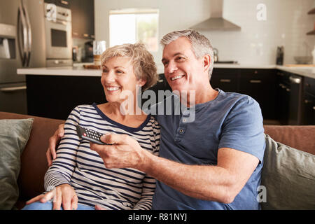 Senior couple sitting on couch watching television, close up Stock Photo