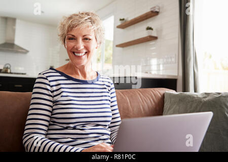 Senior white woman using laptop at home,  looking to camera Stock Photo