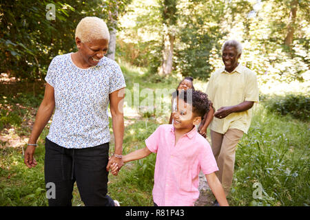 Black senior couple walking in forest with grandchildren Stock Photo