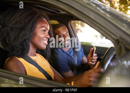 A young black man checks smartphone during a road trip Stock Photo