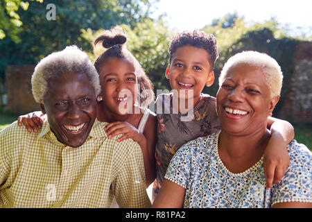 Senior black couple sitting outdoors with grandchildren Stock Photo