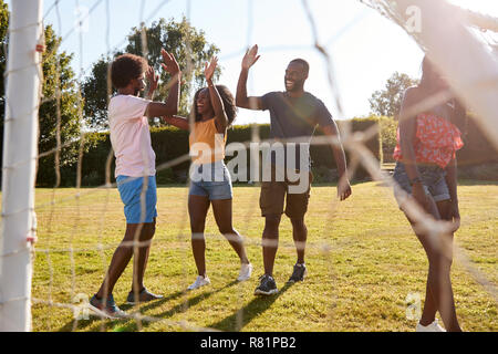 Black adult friends high five during a fun game of football Stock Photo