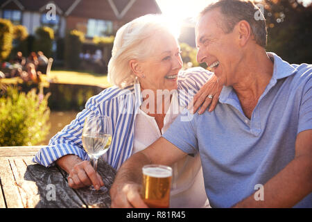 Senior Couple Sitting At Table Enjoying Outdoor Summer Drink At Pub Stock Photo