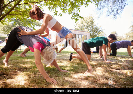 Female Instructor Leading Outdoor Yoga Class Stock Photo