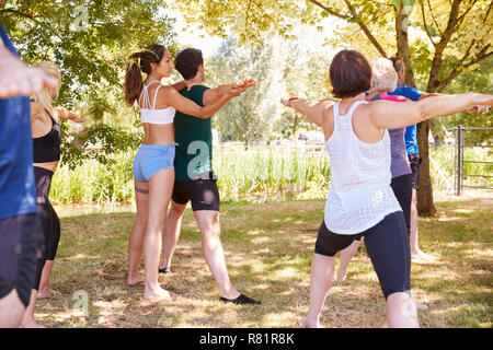 Female Instructor Leading Outdoor Yoga Class Stock Photo