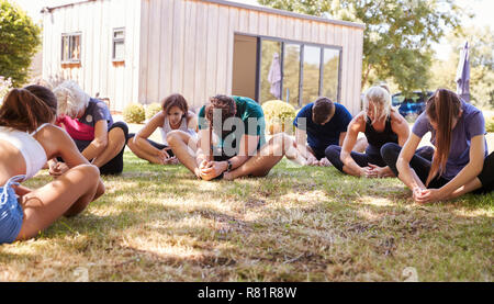 Female Instructor Leading Outdoor Yoga Class Stock Photo