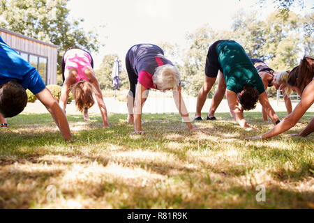 Female Instructor Leading Outdoor Yoga Class Stock Photo