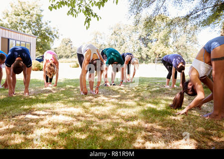 Female Instructor Leading Outdoor Yoga Class Stock Photo