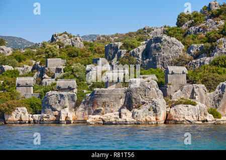 Coast of the island in the Mediterranean sea, picturesque with the ruins of ancient Lycian towns and tombs-sarcophagi of Aperlai, Simena Teimussa Doli Stock Photo