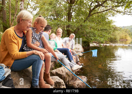 Multi Generation Family Fishing With Nets In River In UK Lake District Stock Photo