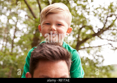 Close Up Of Father Carrying Son On Shoulders On Walk By River Stock Photo