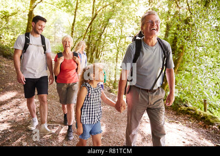 Multi Generation Family Enjoying Walk Along Woodland Path Together Stock Photo