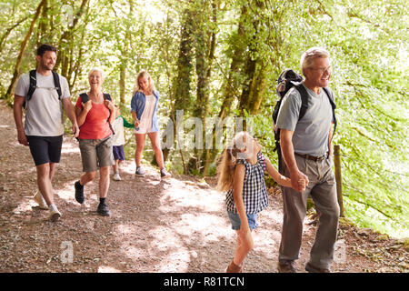 Multi Generation Family Enjoying Walk Along Woodland Path Together Stock Photo