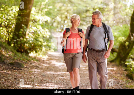 Senior Couple Hiking Along Woodland Path In Lake District UK Together Stock Photo