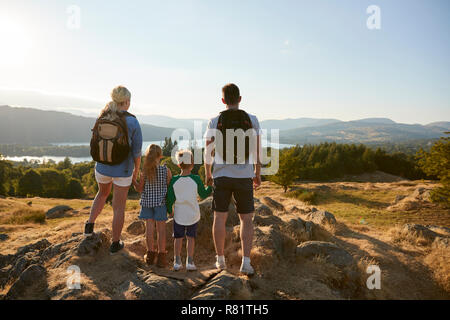Rear View Of Family Standing At Top Of Hill On Hike Through Countryside In Lake District UK Stock Photo