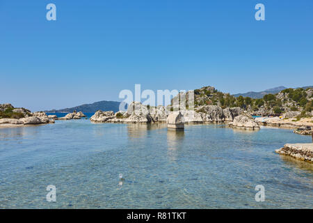 Coast of the island in the Mediterranean sea, picturesque with the ruins of ancient Lycian towns and tombs-sarcophagi of Aperlai, Simena Teimussa Doli Stock Photo