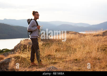 A young mixed race man standing alone on a hill Stock Photo