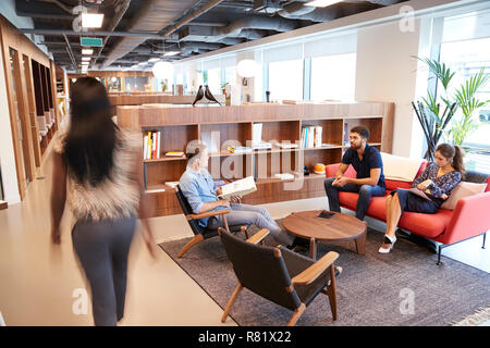 Casually Dressed Businessmen And Businesswomen Having Informal Meeting In Modern Office Stock Photo