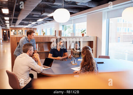 Casually Dressed Businessmen And Businesswomen Having Informal Meeting In Modern Office Stock Photo