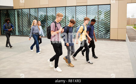 Group Of High School Students Walking Out Of College Building Together Stock Photo