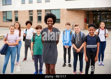 Portrait Of Smiling High School Student Group With Female Teacher Standing Outside School Buildings Stock Photo