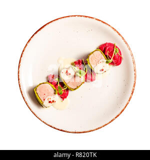 Green crusted Pork loin rolled in peanuts and hazelnuts, mashed potatoes with beetroot and cheese sauce on white background Stock Photo
