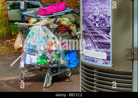 Portland, Oregon, USA - October 8, 2016:  A homeless shopping cart full of possessions and a clear sack of collected returnable cans Stock Photo