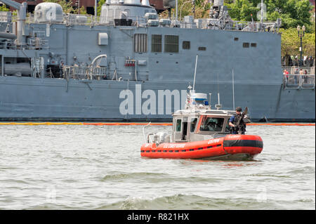Portland, Oregon, USA - June 10, 2012: Coast Guard 25-foot Defender-class boat enforces a security zone around the Navy's USS Dewey ship during Portla Stock Photo