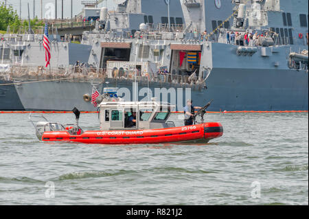 Portland, Oregon, USA - June 10, 2012: Coast Guard 25-foot Defender-class boat enforces a security zone around the Navy ship, USS Dewey, during Portla Stock Photo