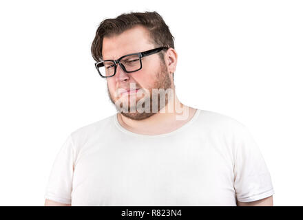 Young bearded man in glasses frowning of bad smell looking deeply displeased on white background Stock Photo