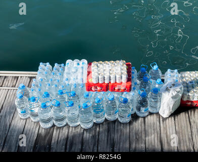 Plastic bottles of water waiting to be loaded on to yacht in marina. Stock Photo