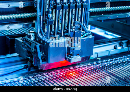 Close-up surface-mounting machine in progress. SMT (surface-mount technology) is a method for producing electronic circuits. Components are placed directly onto the surface of printed circuit boards. Stock Photo