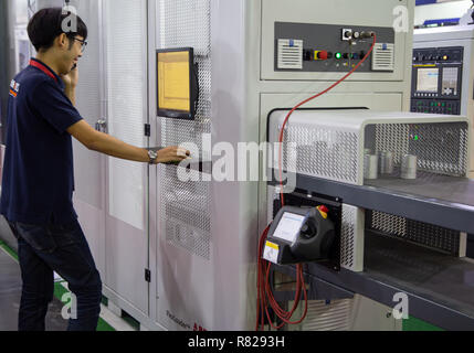 Bangkok, Thailand - November 21, 2018: Worker operate automation robotic arm flexible loader machine in Metalex 2018 Stock Photo