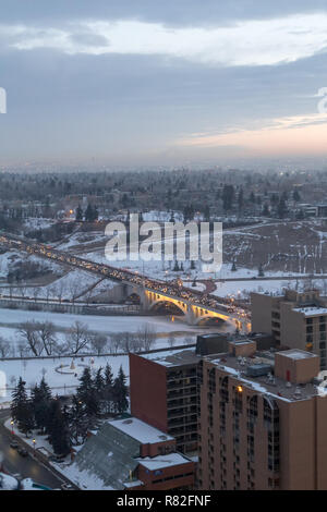 Bird view of the Louise Bridge crossing the Bow River in Calgary Downtown during morning traffic commute in winter under a cloudy sky Stock Photo