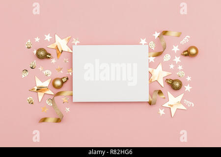 Gold Christmas cracker with a blank white label. luxury gold festive cracker on a pastel pink background Stock Photo