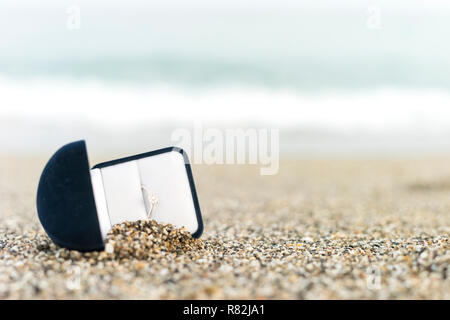 Engagement ring with diamond in elegant box on the beach Stock Photo