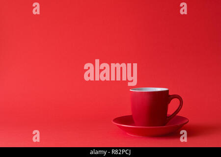 Red cups of tea or coffee on red paper background. Copy space Stock Photo